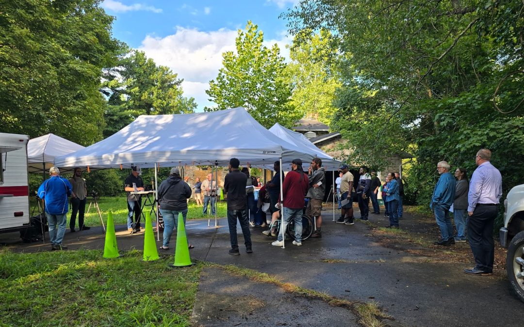 Real estate auction in Ohio with bidders gathered under tents, hosted by Hoffman Auctions