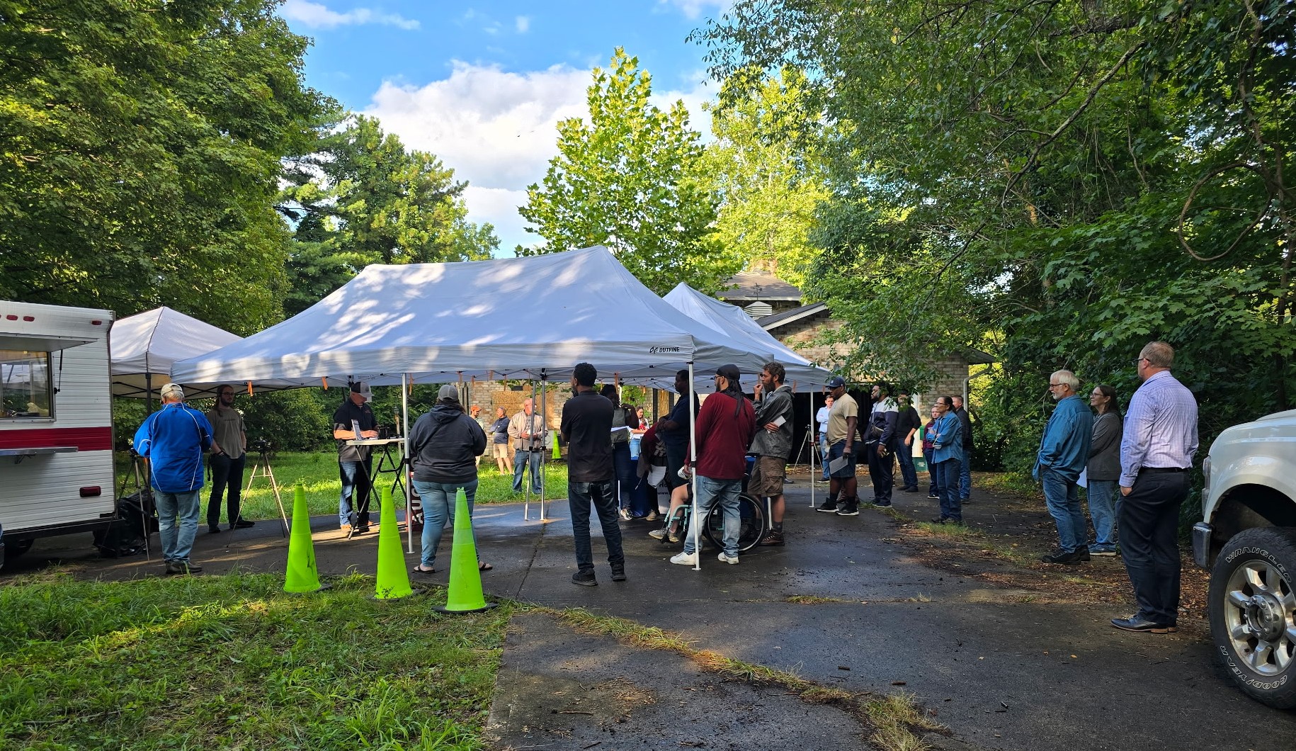 Real estate auction in Ohio with bidders gathered under tents, hosted by Hoffman Auctions